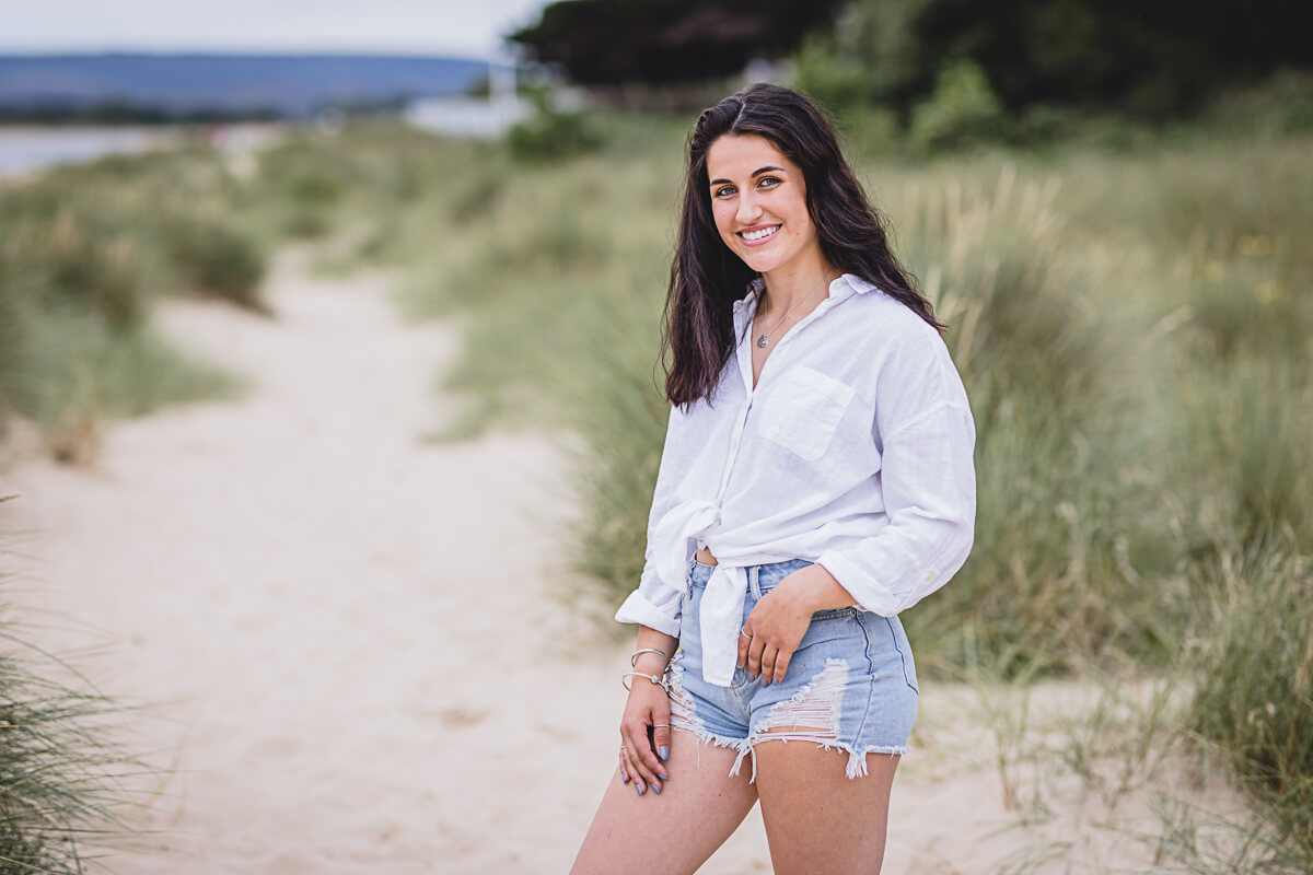 Girl wearing jean shorts on Sandbanks beach, Dorset