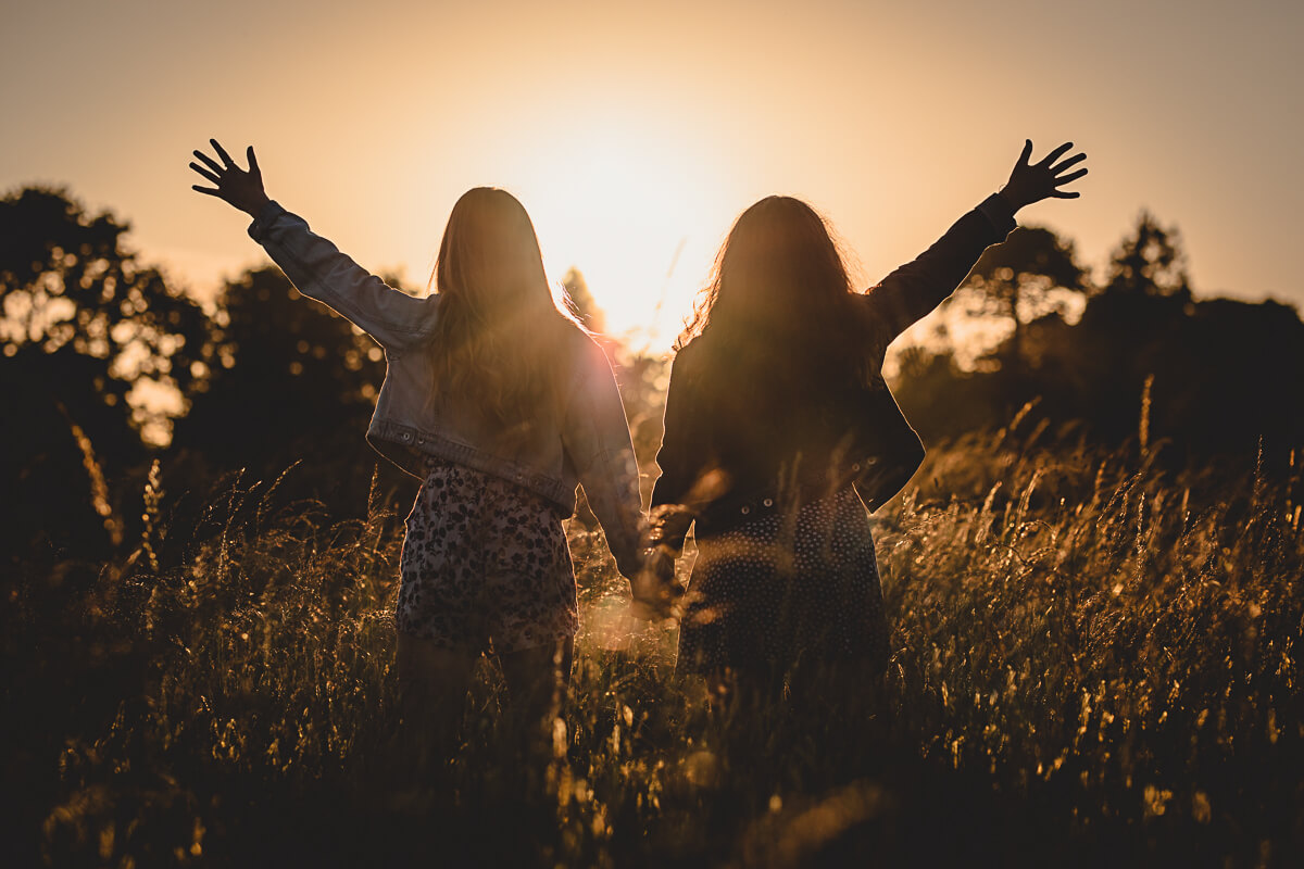 Golden hour portrait of sisters in a field, Dorset