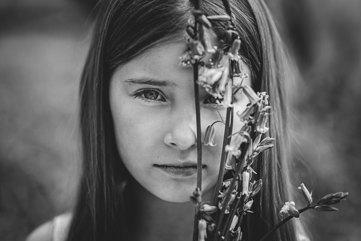Black & White image of young girl holding bluebells