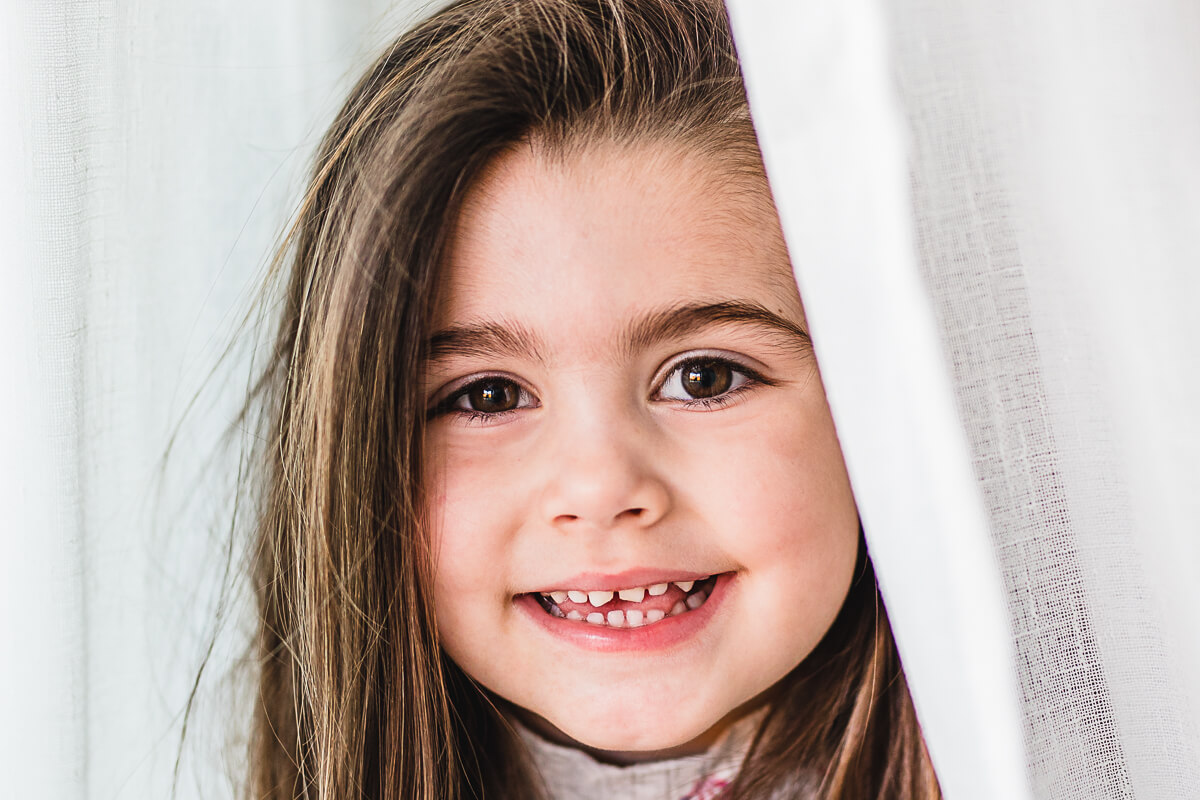 Portrait of a little girl in white curtain
