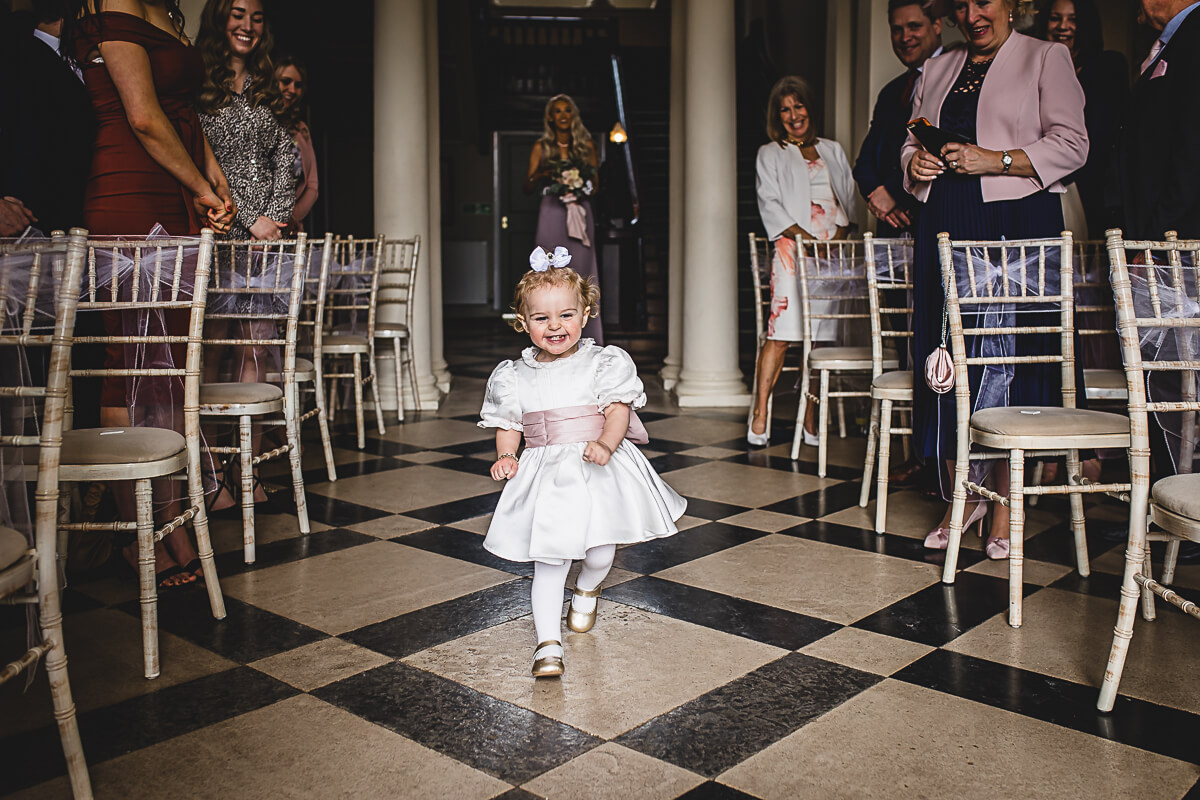 Little flower girl running down the aisle at Crowcombe Court, Somerset