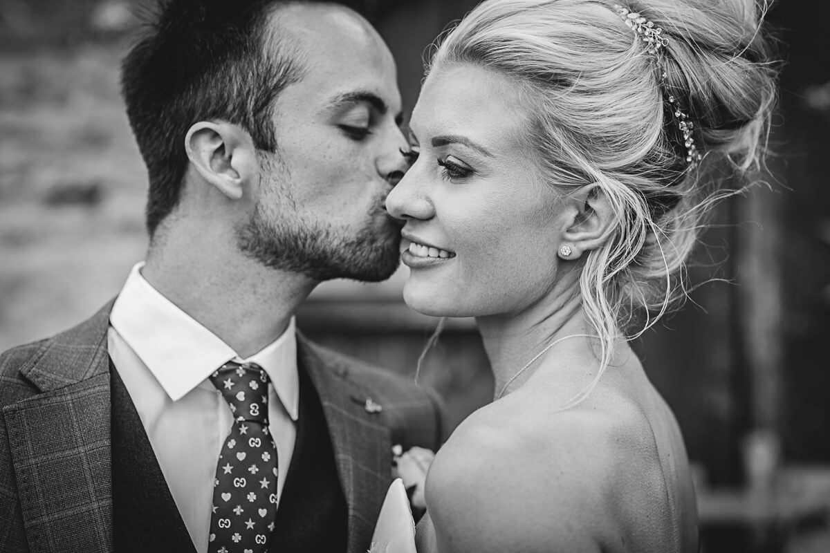 Close up of Groom kissing the Bride on her cheek taken by Photography by Chantel