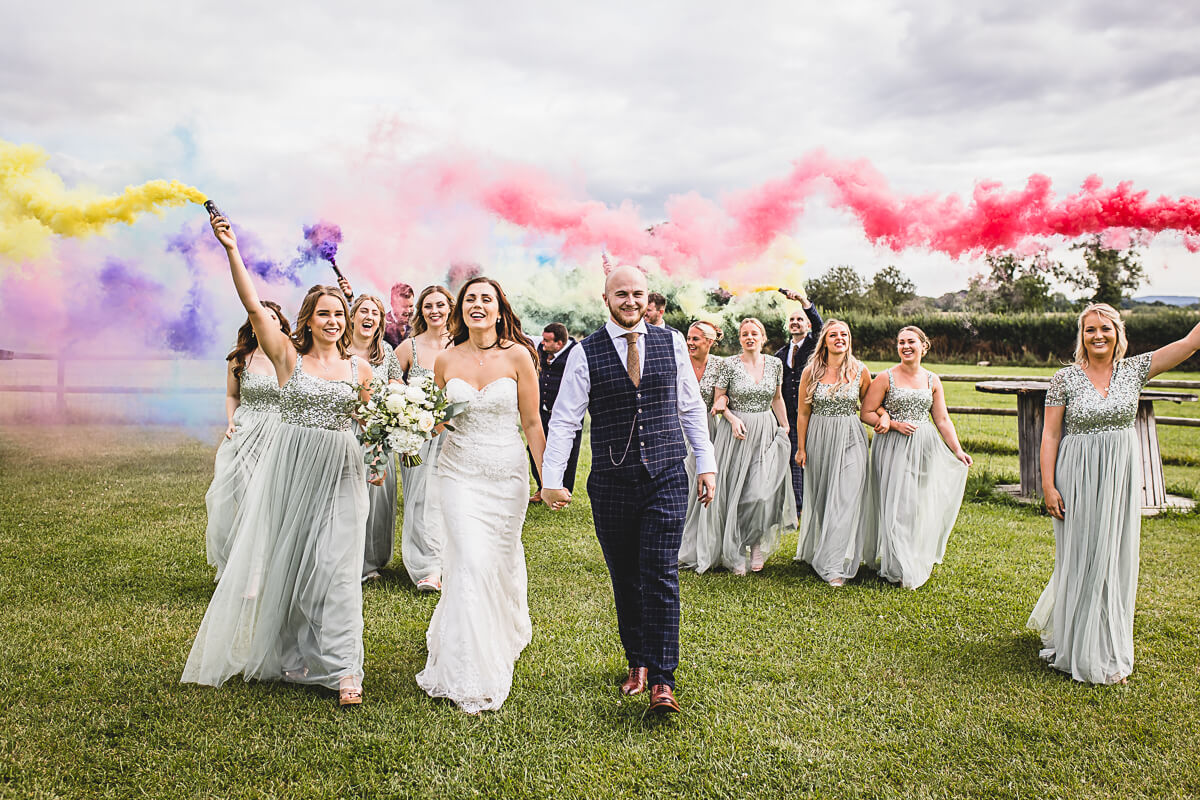 Wedding Party walking with coloured Smoke Bombs