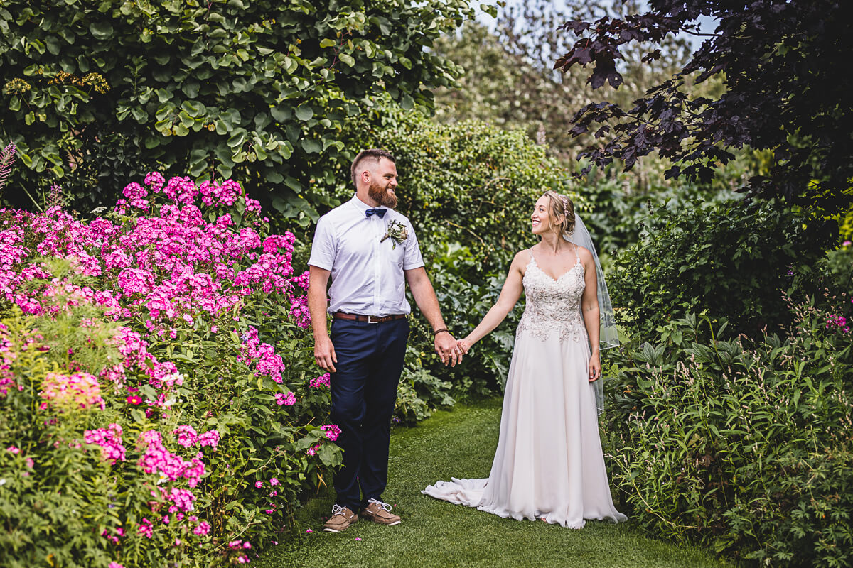 Bride and Groom holding hands in the gardens at Parley Manor, Dorset