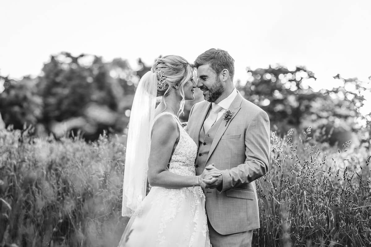 Bride and Groom holding hands and touching noses at Parley Manor, Dorset