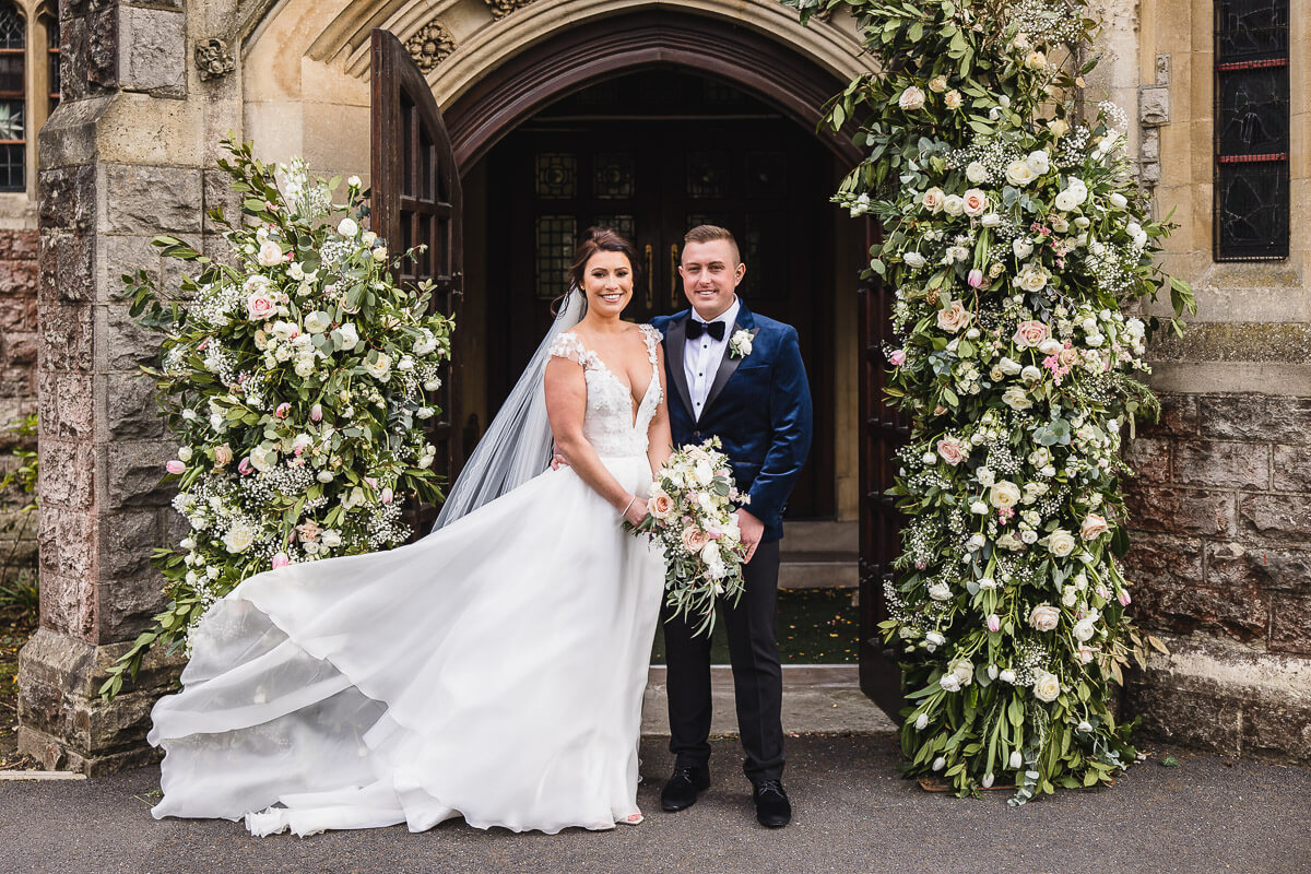 Bride and Groom smiling outside church doors in Dorset