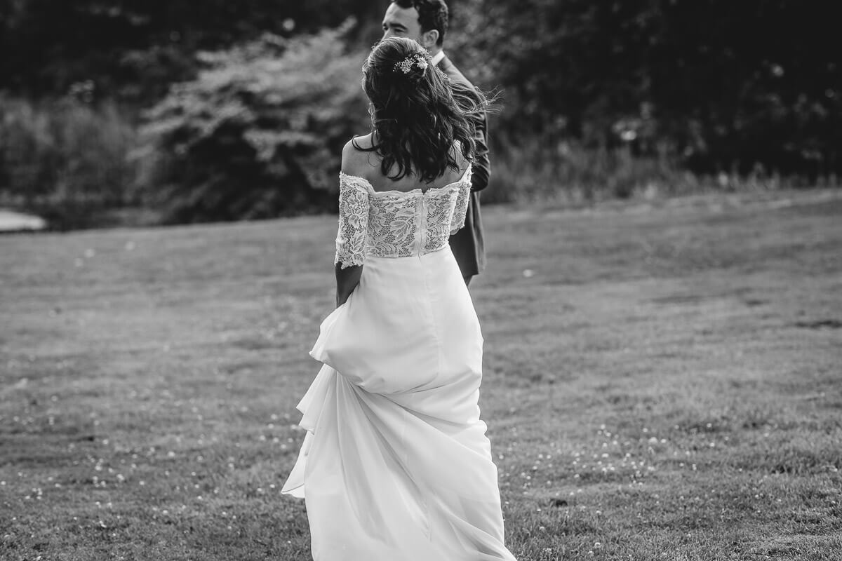 The back of the brides dress as she walks with the groom at Crowcombe Court Wedding