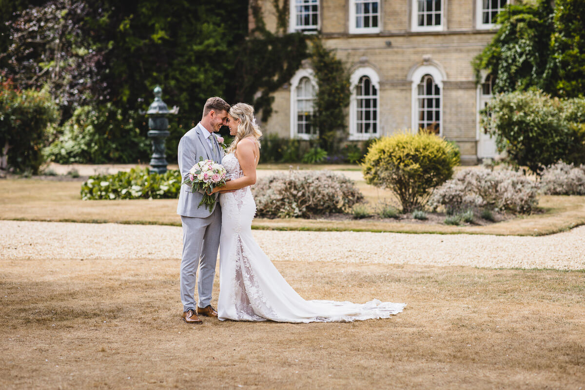 Bride and groom cuddling outside the house at Pylewell Park