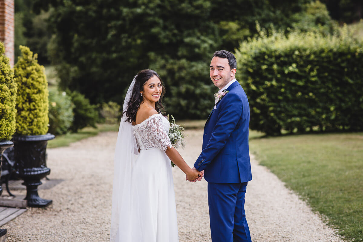 Bride and Groom holding hands and smiling at their Crowcombe Court Wedding