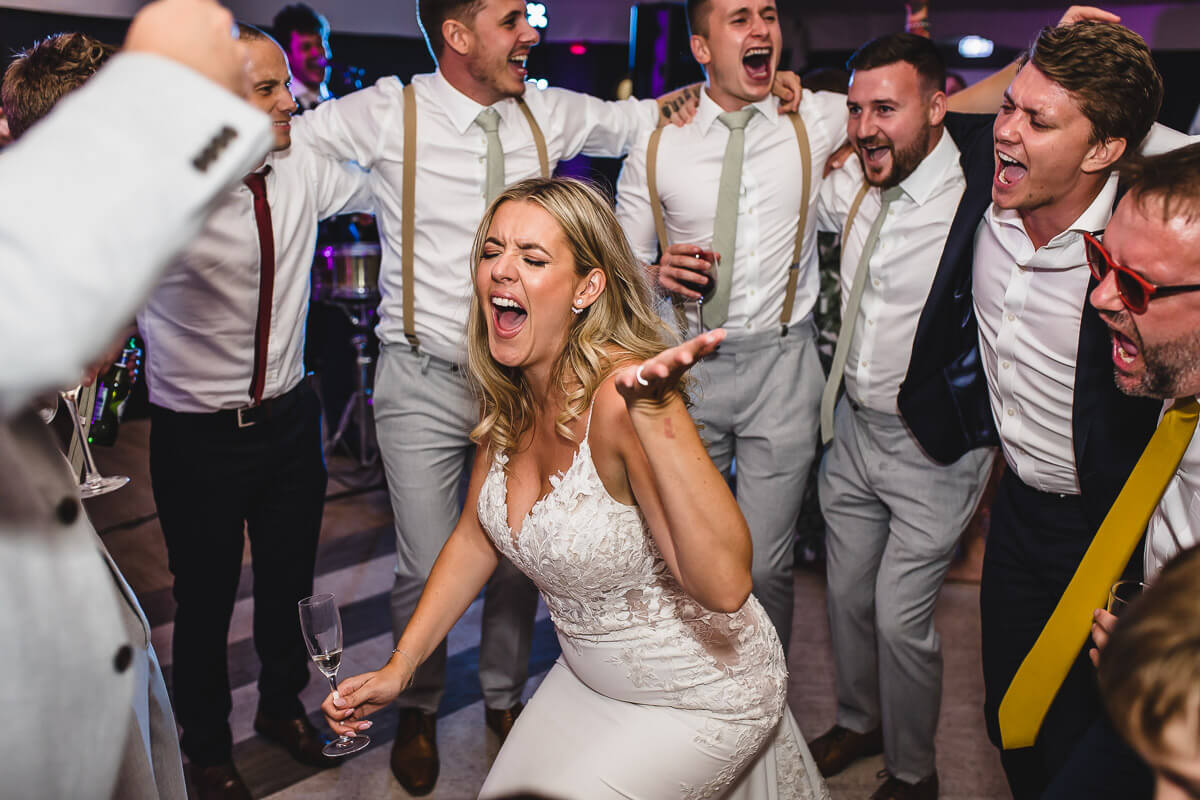 Bride dancing and singing on the dancefloor at Pylewell Park, Hampshire
